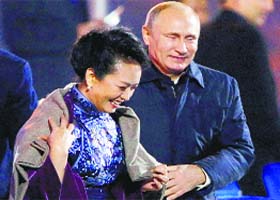 Chivalrous Putin: Russias President Vladimir Putin puts a shawl on Peng Liyuan, wife of Chinese President Xi Jinping as they arrive to watch a fireworks show in Beijing