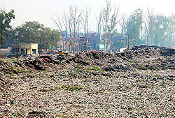 Residential houses can be seen at the back of the Bhagtanwala dump in Amritsar on Wednesday