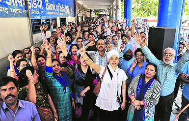 Members of the United Forum of Bank Unions gather at Bank Square, Sector 17, in Chandigarh during their strike on Wednesday; and (below) a locked branch.