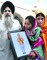 Mehram's mother holds his portrait as she comes out of a gurdwara after the bhog ceremony at Phase IX in Mohali on Wednesday. 
