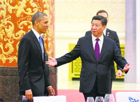 Chinese President Xi Jinping gestures to his US counterpart Barack Obama as they arrive at the Great Hall of the People in Beijing on Wednesday. 