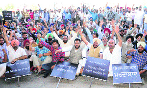 Shopkeepers and leaders of various political parties along with residents stage a protest against installation of iron grills on either side of Airport road in Amritsar on Thursday.