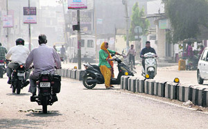 A two-wheeler rider waits at a gap in the divider on Bhatti Road for the traffic flow to grow thin to cross it in Bathinda on Thursday