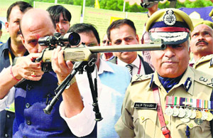 Home Minister Rajnath Singh inspects a weapon during the Diamond Jubilee celebrations of the CRPF at Kadarpur Group Centre in Gurgaon on Thursday