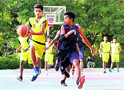 Players of Hilton School and Pestalweed School battle to take control of the ball during a match in the 26th All-India Inter School WC Kashyap Basketball Tournament at Pestalweed School in Dehradun on Thursday
