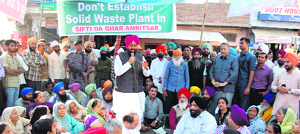 PPCC chief Partap Singh Bajwa addresses residents living in the vicinity of the Bhagtanwala dump yard in Amritsar on Friday.