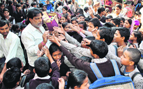 Former MC Vijay Kumar gives away pencils to schoolchildren at Government School in Paras Ram Nagar in Bathinda.