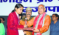 Governor Kaptan Singh Solanki honours a student at Arya PG College in Panipat on Friday