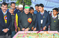 Students demonstrate a model to Health Minister Kaul Singh Thakur at the science congress in Mandi on Friday. photo: Jai Kumar