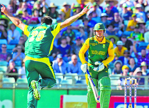 South African Quinton de Kock walks as Mitchell Johnson runs in to celebrate during the first ODI in Perth on Friday.