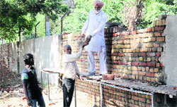 Boundary wall of Govt Rajindra College being rebuilt on Saturday. Tribune photo: Pawan Sharma