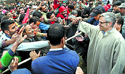Chief Minister Omar Abdullah shakes hands with supporters during an election meeting at Doderhama in Ganderbal district on Saturday