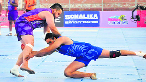 A United Singhs player (right) tries to stop a Vancouver Lions raider during their World Kabaddi League match in Ludhiana on Saturday.