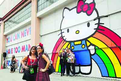 Fans pose in front of a Hello Kitty mural at the Geffen Contemporary at MOCA in Los Angeles, California.