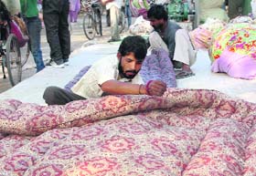 Winter preparation: A quilt maker at work as the temperature dropped in Bathinda on Sunday