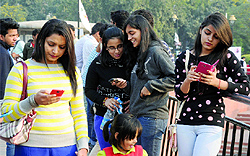 People check the Internet connection on their mobile phones after the launch of Wi-Fi access at Central Park in Connaught Place on Sunday