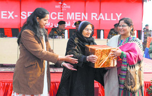 A family member of an ex-serviceman receives a gift at a rally in Srinagar on Sunday.