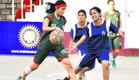 Players of St. Joseph Academy (green) and DAV Public School (blue) try to take control of the ball during a match in the Indian School Basketball League at Doon International School in Dehradun on Sunday.