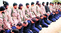 An image grab taken from a video released by al-Furqan Media on Sunday allegedly shows members of the Islamic State preparing the beheadings of 18 men described as Syrian military personnel