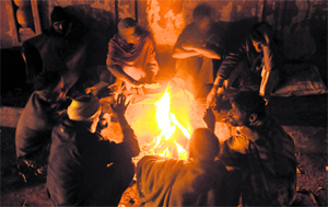 With temperature dipping in the region, people sit around a bonfire to get warmth on a chilly night in Amritsar on Monday.