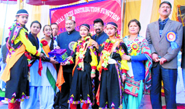 Health Minister Kaul Singh Thakur gives prizes to students during an annual function at Barot in Mandi on Sunday.