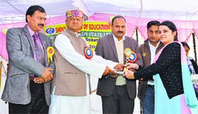 Neha Dogra of DPGCE, Rait, receives the first prize in a debate on the Kashmir issue at Ghumarwin on Saturday.