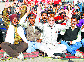 Employees under the banner of the J&K National Trade Union Front protest in Jammu on Monday. 