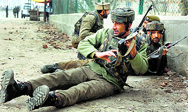 Security personnel take cover during a militant attack in Srinagar. 