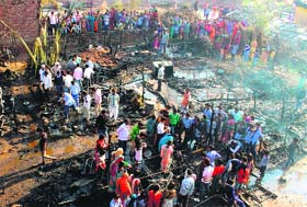 Residents gather at the spot after their shanties were reduced to ashes in a major fire at Madanpur village in Sector 26, Panchkula, on Tuesday