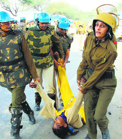 Security personnel take away a Rampal supporter during a clash in Hisar on Tuesday.