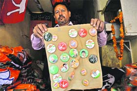 A shopkeeper display flags, banners and symbols of various political parties in Jammu