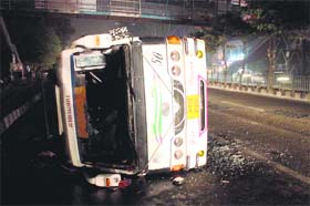 Narrow escape: A speeding minibus overturns on the road at Gandhi Nagar in Jammu. No passenger was injured in the mishap