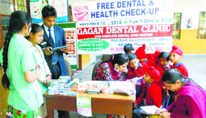 A health official examines a student during a dental camp at BCM Kindergarten in Basant Vihar