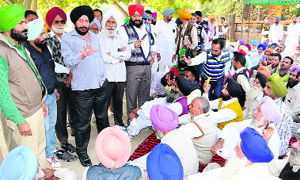 Gurdeep Singh, senior manager, Central Cooperative Bank Ltd, pacifies the protesting farmers and cooperative employees in Bathinda on Wednesday.