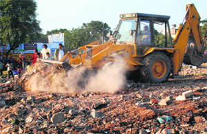 A JCB machine demolishes temporary structures on HUDA land during an anti-encroachment drive at Sector 14 in Panchkula on Wednesday