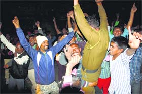Rejoicing: People, along with a policeman, dance after the arrest of Rampal at Barwala in Hisar district on Wednesday