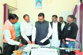 Gharaunda MLA Harvinder Kalyan examines the attendance register at the tehsil office on Wednesday