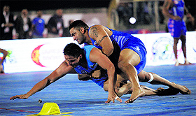 A United Singhs player trying to stop a California Eagles raider from earning a point during their semifinal of the World Kabaddi League in Mohali on Wednesday