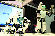 Humanoid robots of Robotis move as they are on display during the 2014 IEEE-RAS International Conference on Humanoid Robots in Madrid