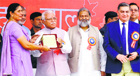 Chief Minister Manohar Lal Khattar gives away an award to the chairperson of a cooperative society at the 49th annual function of state cooperatives at the HUDA grounds in Ambala on Thursday.