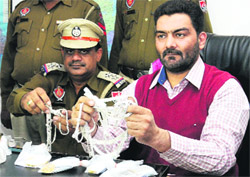 Policemen show valuables looted by the seven members of an inter-state gang which was busted in Jalandhar on Thursday. 