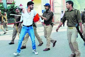 Police personnel detain an agitating student at Banaras Hindu University on Thursday