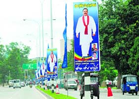 Sri Lankan motorists drive past multiple posters of President Mahinda Rajapakse in Colombo on Thursday