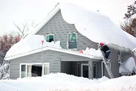 The big chill: A man climbs on his roof to clear snow in the town of Cheektowaga near Buffalo, New York