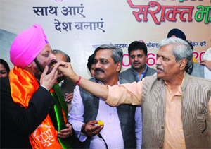 Former Delhi Assembly Speaker MS Dhir joins the BJP in the presence of Delhi party in charge Prabhat Jha (R) and Delhi party president Satish Upadhaya (C) at a function in New Delhi on Friday. 