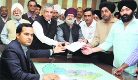 The Industrial and Traders Joint Action Committee present a memorandum against the government over the issue of regularisation of industrial plots, property tax and enhancement in licence fee in Jalandhar on Friday.