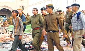 The police take a suspected Rampal commando into custody at Satlok Ashram.