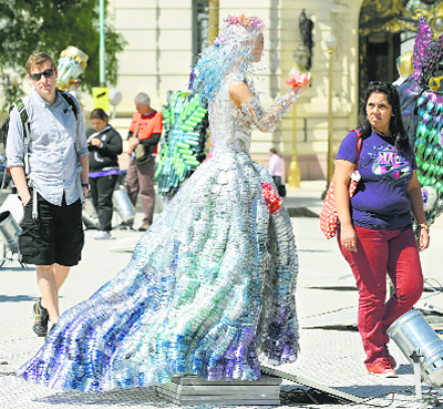 People observe the sculpture “Dama del Rio” made by students of the school “Homero Manzi” and displayed as part of the Outdoor Exhibition, in Plaza San Martin in Buenos Aires. Groups of students from technical and art high schools called “Earth Keepers”, worked in sculptures made entirely with plastic wastes.
