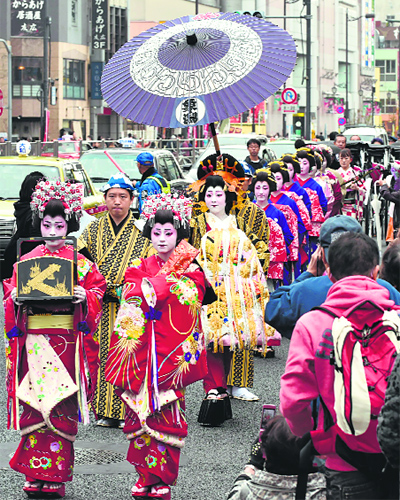 A woman (C), performing as an “Oiran”, a high-class courtesan in the Edo period (1600-1868), walks during the “Oiran Dochu” parade in Tokyo Asakusa.