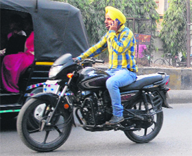 A youngster uses mobilephone while riding a motorcycle